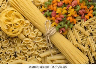  A variety of uncooked pasta types including spaghetti, shells, farfalle, fusilli, tagliatelle, and colorful spirals neatly arranged on a rustic wooden surface - Powered by Shutterstock