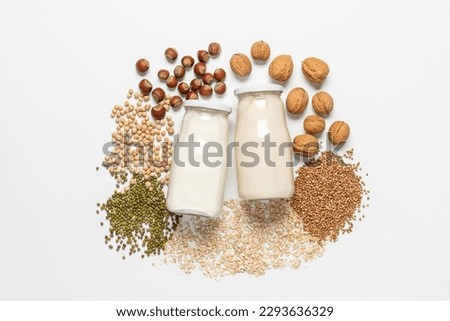 Variety of vegan plant based milk in glass bottles. Top view of lactose free milk based on nuts, legumes, oatmeal on white background