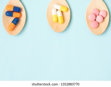 Variety of vitamin pills in wooden spoon on blue background. Healthcare concept. - Shutterstock ID 1352883770