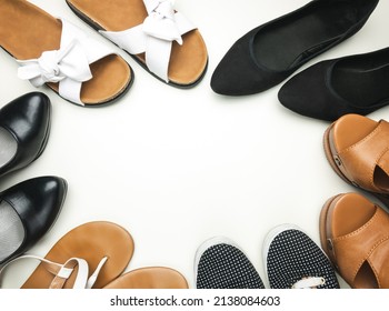 Variety of women's shoes on white background with copy space. Trainers, wedges, flat ballerina shoes or ballet flats, flip-flops thongs, sandals and heels.