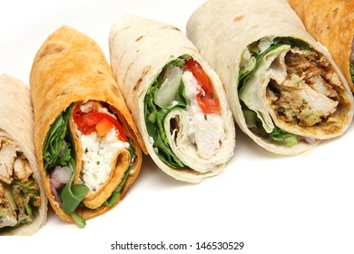 Variety of wrap sandwiches with chicken and feta cheese.
