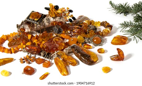 Variety Of Yellow-orange Baltic Amber Jewelry And Amber Stones On A Birch Bark. Isolated Object On A White Background. Amber Texture, Material For Jewelers, Alternative Medicine, Stone Healing.