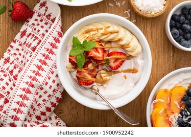 Variety Of Yogurt Bowls With Strawberry And Plain Yogurt, Fruit And Granola