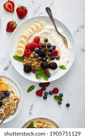 Variety Of Yogurt Bowls With Strawberry And Plain Yogurt, Fruit And Granola