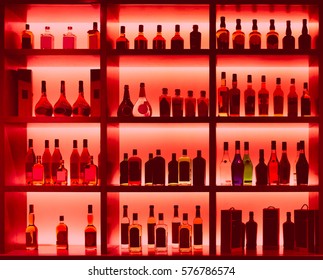 Various alcohol bottles in a bar, back light, all logos removed, toned image