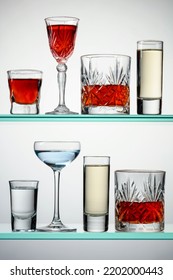Various Alcoholic Drinks In The Bar On Glass Shelves.