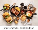 Various of american food, French fries, hamburgers, chips, popcorn, snacks and sauces on a white background, top view.