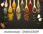 Various Asian spices in spoons on black background. Top view.