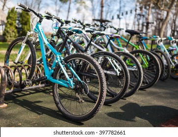 Various bicycles on a rack, available for rent - Powered by Shutterstock