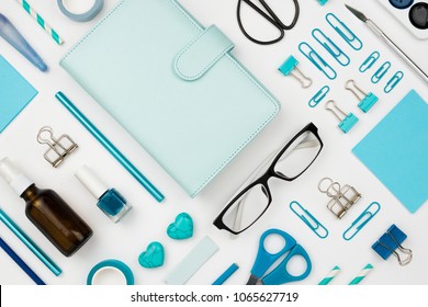 Various Blue Stationary And Office Tools And Accessories Knolled Together On White: Planner, Pens, Pencils, Clips, Glasses, Scissors, Etc. Flatlay