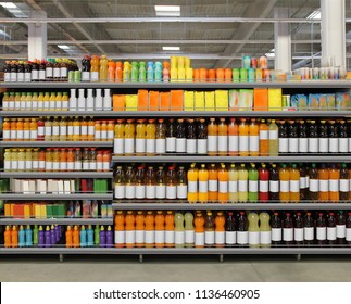 Various bottles of juice, soda, water, vitamins on shelf at supermarket
