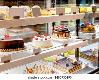 Various Cake with Icing in Refrigerated Bakery Case Cabinet. Chocolate and Cherry Tart Topping on Fridge Display at Culinary Center. Selective Focus - Shutterstock ID 1480930193