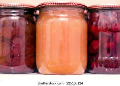 Various Canning Fruit Jams In Glass Jars On A Shelf In The Pantry