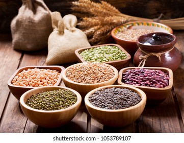 various cereals, seeds, beans and grains on wooden table