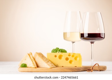 Various cheese on board, red and white wine. With copy space