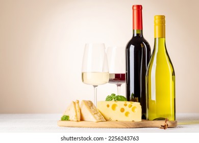 Various cheese on board, red and white wine. With copy space