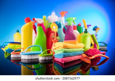 Various cleaning items and supplies on blue background. 