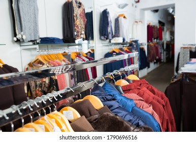 Various coats and blouses on hangers in clothing shop interior - Shutterstock ID 1790696516