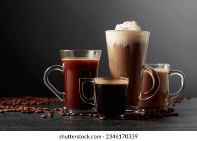 Various coffee and chocolate drinks with scattered coffee beans on a black table.
