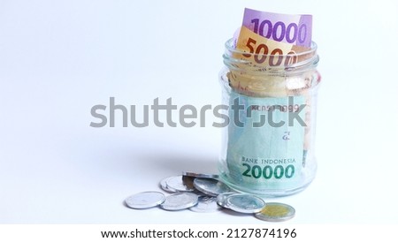 Various coins and paper money of Indonesian rupiah. Concept of finance, investment, economy, business and success. Money in glass cup. Saving your money. Uang 10000 20000 5000 Rupiah Indonesia