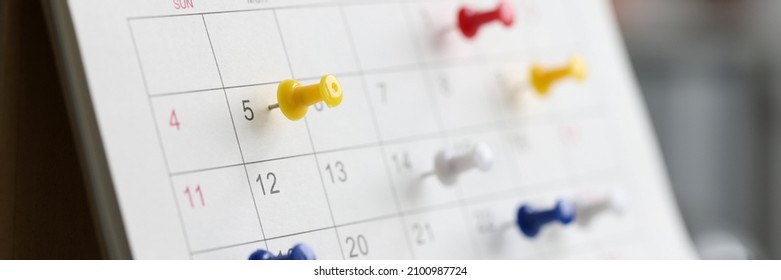 Various color thumb tack pins on calendar as reminder. Important business days concept
