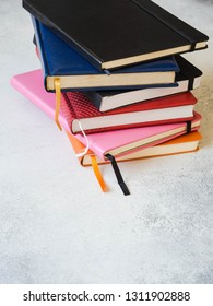 Various colored note pads. Stack of notebooks on grey background. Copy space