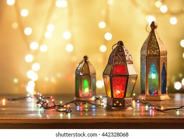 Various colorful Ramadan lamps lit up against illuminated decorative lighting background.