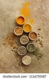 Various colorful spices in small jars on beige concrete background. Top view, flat lay - Shutterstock ID 1116735587