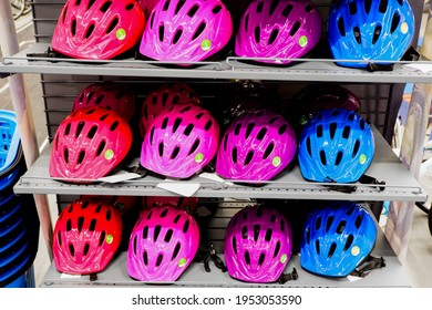 Various colors bike helmets on sport store display. Bicycle safety accesories shopping