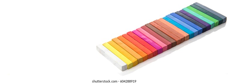Various colors of chalk pastel sticks over white background