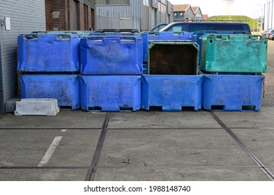 Various Colors Large Fish Crates Stored Outside In Use To Store Fish Waste