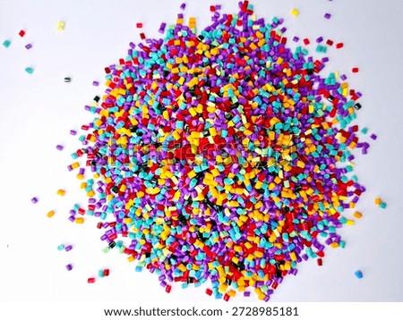Various colors of masterbatch granules mixed on a white background.Color pigment carrier polymers in the plastics industry