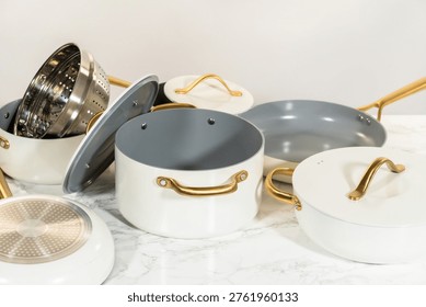 Various components of a ceramic cookware set including pots, lids, steamer insert, and frying pans laid out separately for display. Useful for tutorials, blogs, or sales pages.