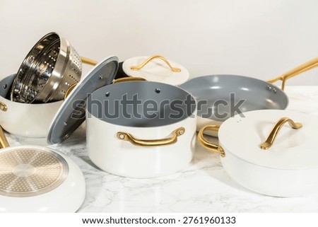 Various components of a ceramic cookware set including pots, lids, steamer insert, and frying pans laid out separately for display. Useful for tutorials, blogs, or sales pages.