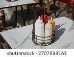 Various condiments on a restaurant table in sunlight