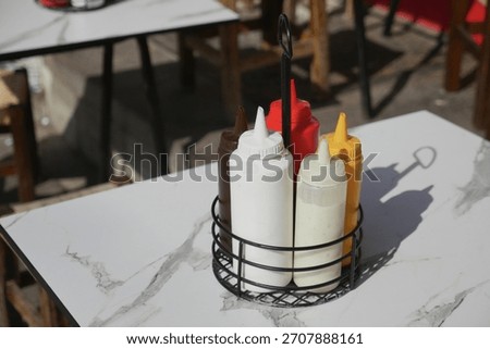 Various condiments on a restaurant table in sunlight