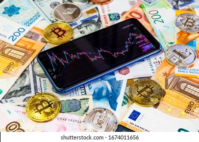 Various cryptocurrencies and a smartphone with a graph. Cryptocurrencies on the background of different banknotes