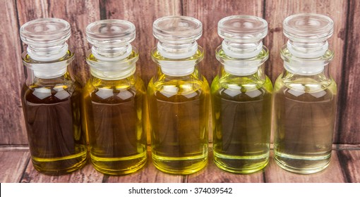 Various culinary oil in glass vial over wooden background