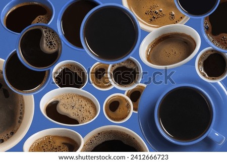 Various cups of coffee are randomly arranged on blue. Abstract background texture