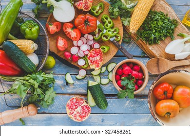 Various Cut Veggies Over On Kitchen Wooden Blue Table With Rustic Spoon. Vegetarian, Organic And Balanced Food Concept. Rustic Style.