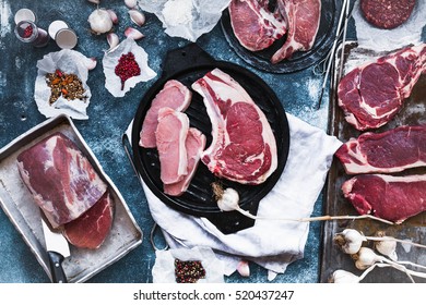 Various Cuts Of Beef And Pork Steak On A Grilled Tray. Overhead Of Beef And Pork Steaks Meat With Spices.