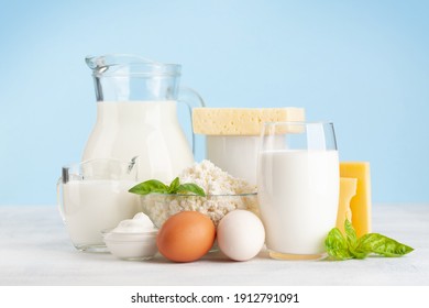 Various dairy products. Milk, cheese, cottage, sour cream. In front of blue background