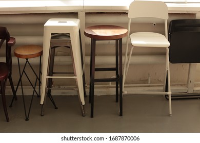 various different set of chairs stools stand along the wall by the window