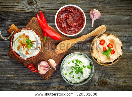 various dip sauces on wooden table, top view