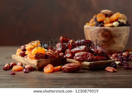 Various dried fruits and nuts on a old wooden table.