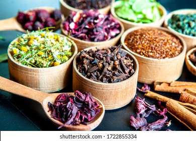 Various dried tea leaves in wooden bowl. Dried herbs tea leaves close up. Different dry herbs and flowers for making healthy tea background.