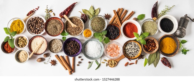 Various dry  spices in small bowls and raw herbs flat lay  on white   background. Top view, copy space
