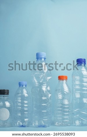 Various empty plastic bottles arranged in a row on a blue background, symbolizing recycling, environmental awareness, and plastic waste management.