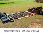 Various equestrian polo equipment displayed on the grass, ready for use, from the blanket to the saddle
