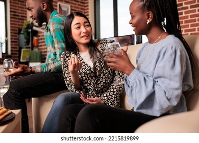 Various Ethnicities Young Adult Women Happily Chatting, Talking, Drinking Wine, Laughing, Having Good Time, Enjoying Appetizers At Apartment Friends Gathering. Ethnicall Variety Partners Having Fun.